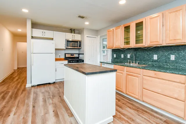 a kitchen with stainless steel appliances granite countertop a stove a sink and a refrigerator