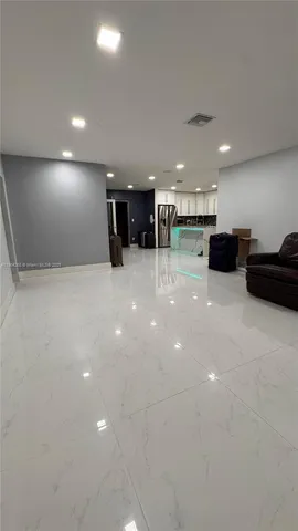 a view of a big room with kitchen a sink and a couch