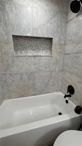 a kitchen with granite countertop white cabinets and a stove