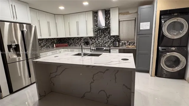 a kitchen with kitchen island a sink a stove and refrigerator