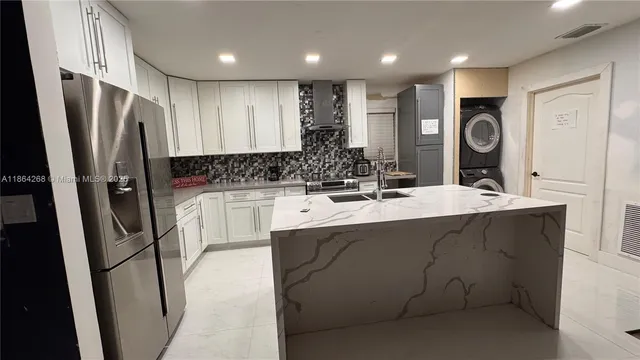 a kitchen with stainless steel appliances a sink stove and refrigerator