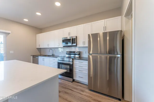 wooden floor in an empty room with a kitchen