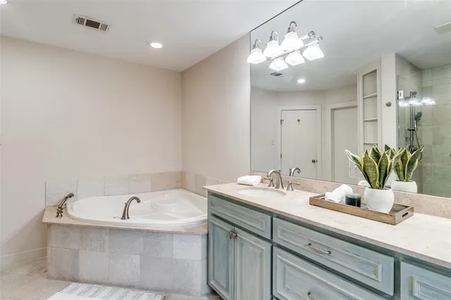 a bathroom with a tub sink and mirror