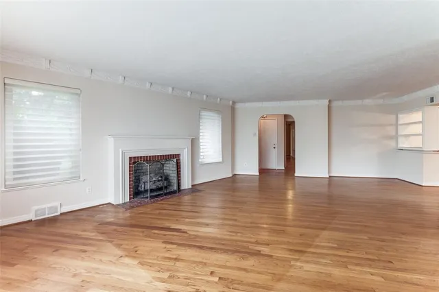an empty room with wooden floor and fireplace