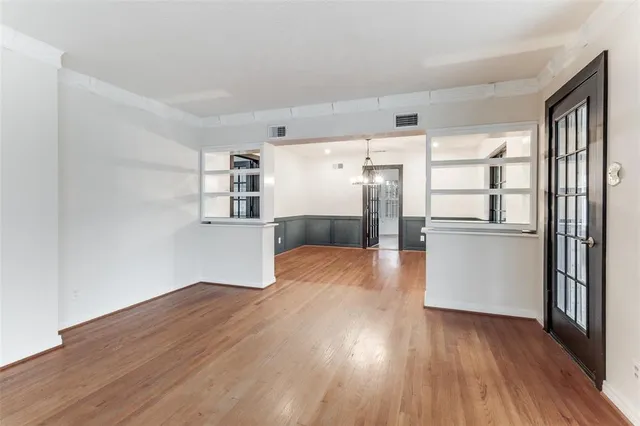 a view of a kitchen with wooden floor electronic appliances and cabinets