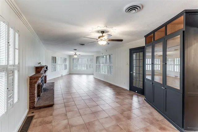 a view of a hallway with windows and chandelier