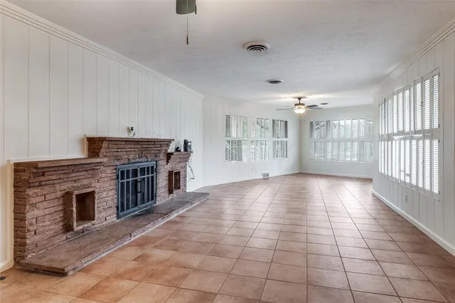 a view of an empty room with fireplace and a window