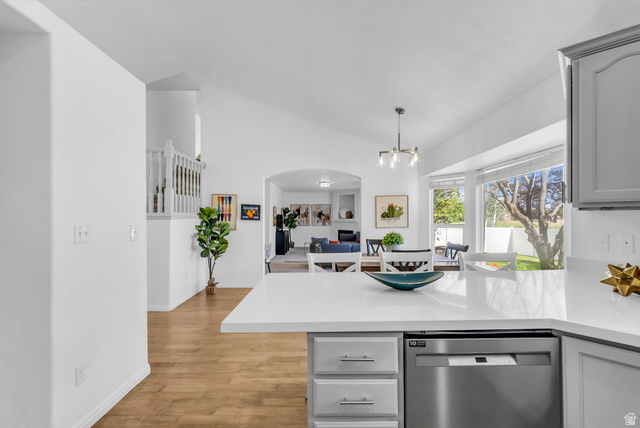 1147 West State Road Lehi, UT 84043 - Photo 10 of 31 Kitchen island with a white countertop and integrated stainless steel dishwasher, opening into a dining area with a bay window and backyard access