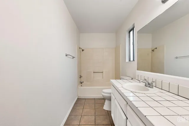 a bathroom with a granite countertop sink a toilet and shower