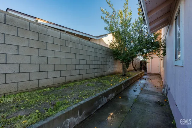 a view of a back yard with an tree and wooden fence