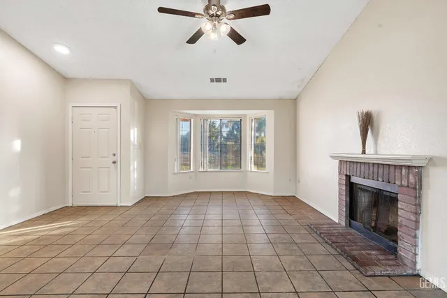a view of an empty room with window and fireplace