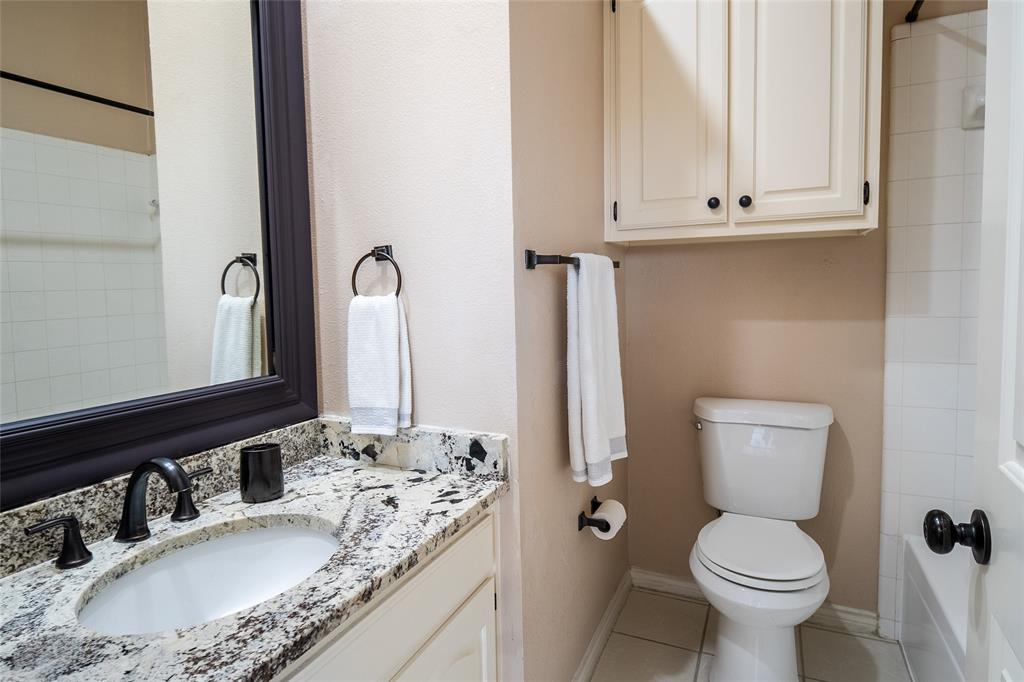 4664 Cherokee Path Carrollton, TX 75010 - Photo 16 of 21 a bathroom with a granite countertop toilet and a sink