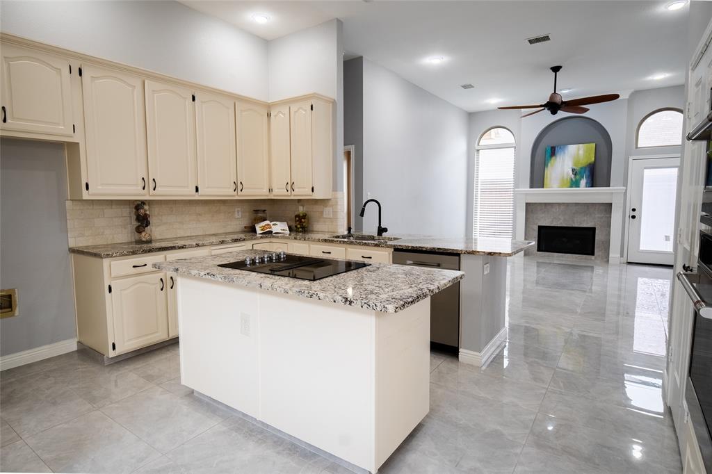 4664 Cherokee Path Carrollton, TX 75010 - Photo 6 of 21 a kitchen with granite countertop a sink a stove and cabinets