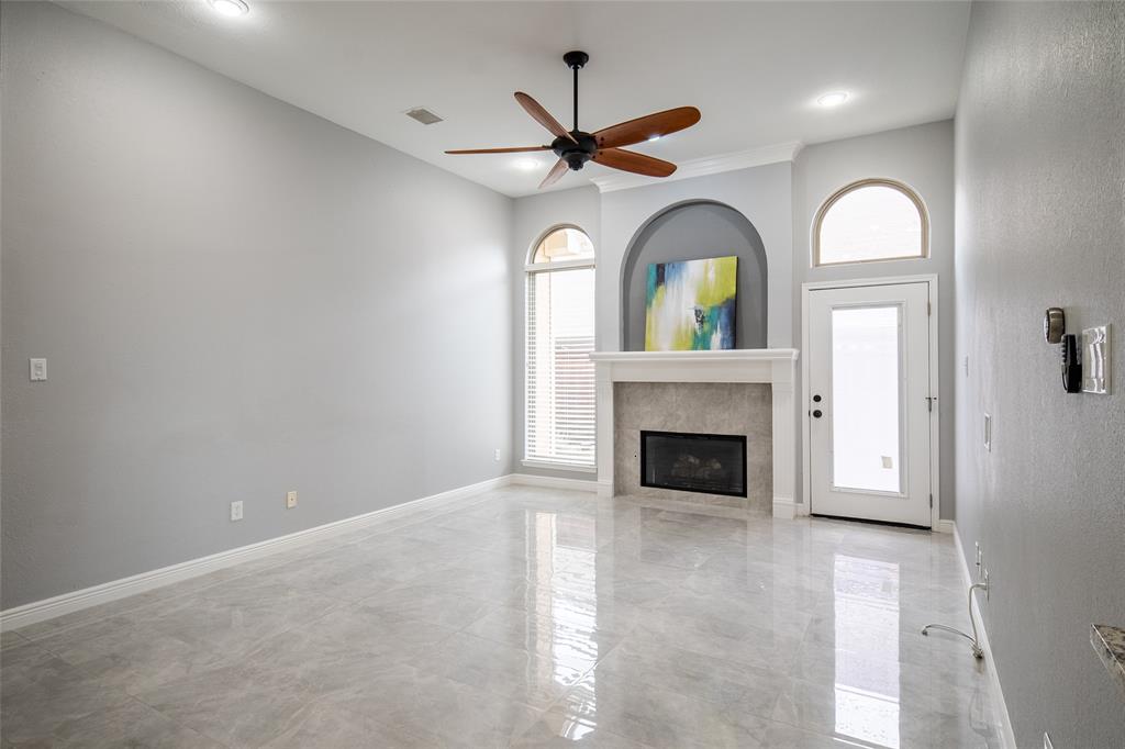 4664 Cherokee Path Carrollton, TX 75010 - Photo 9 of 21 a view of a livingroom with a fireplace a ceiling fan and a fireplace