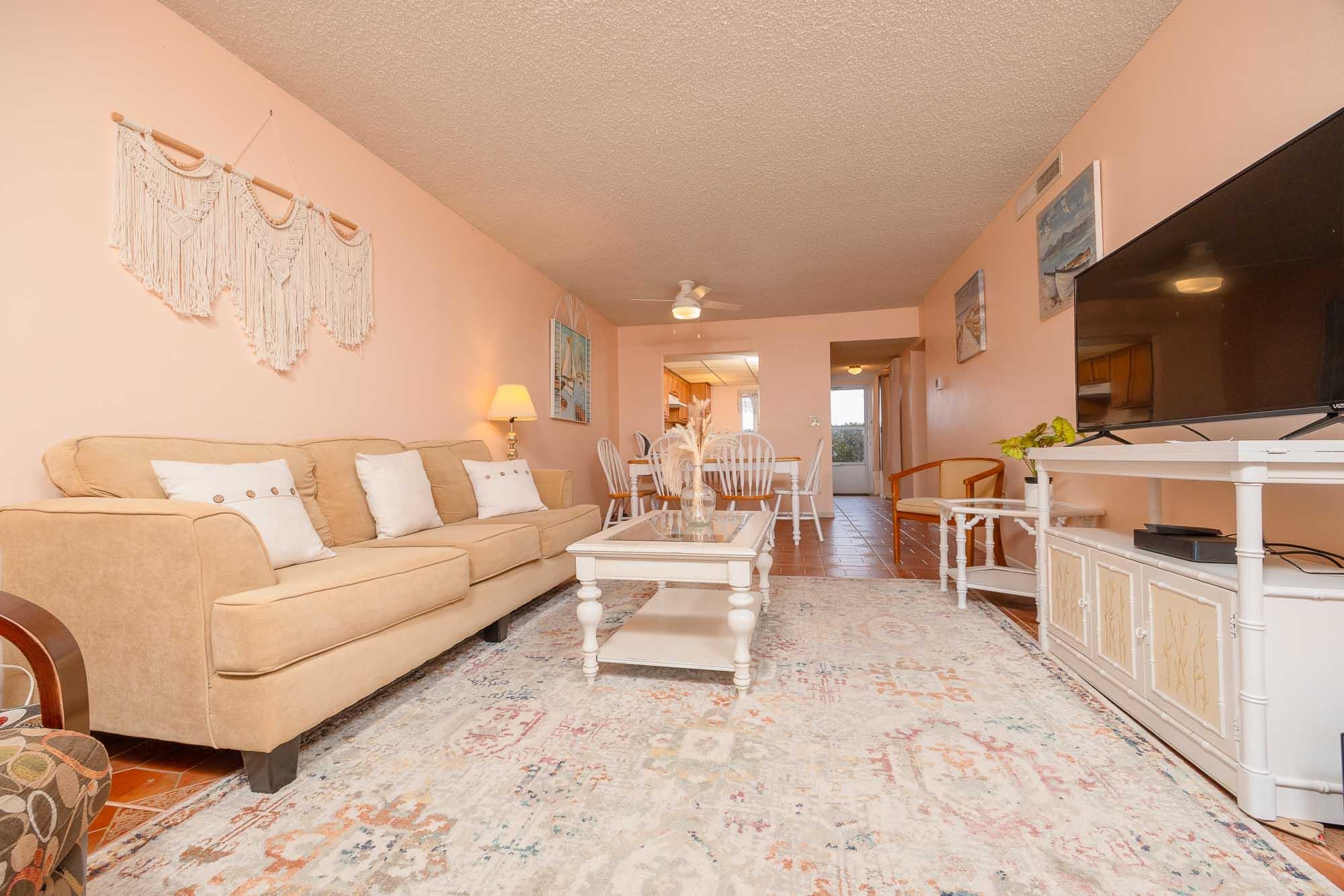 4 Ocean Trace Road, Unit 122 St. Augustine, FL 32080 - Photo 17 of 47 a living room with furniture a flat screen tv and a refrigerator