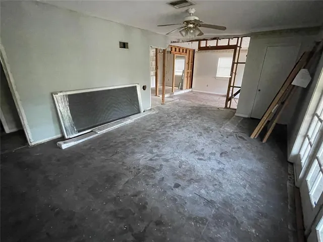 a view of an empty room with a fireplace and a window