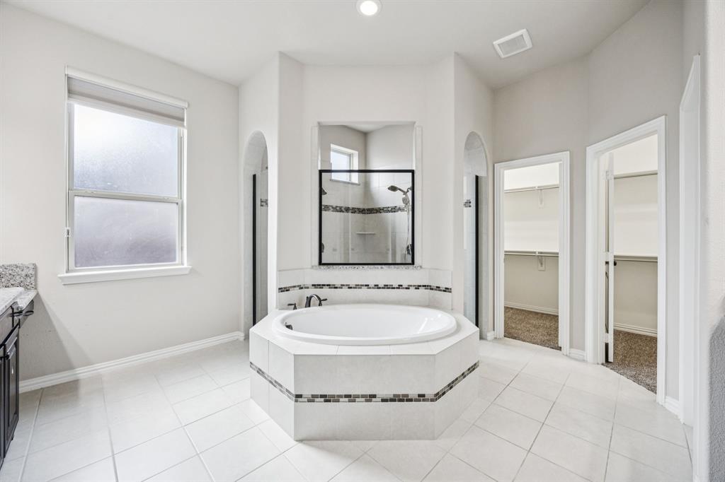7205 Joshua Tree Trail McKinney, TX 75070 - Photo 18 of 32 a spacious bathroom with a tub shower and mirror