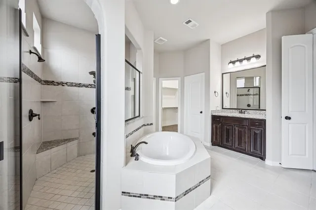 a bathroom with a bathtub shower sink and mirror