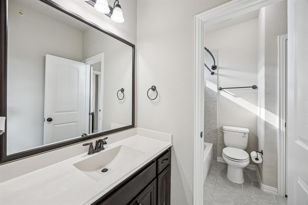 7205 Joshua Tree Trail McKinney, TX 75070 - Photo 28 of 32 a bathroom with a sink toilet vanity and shower