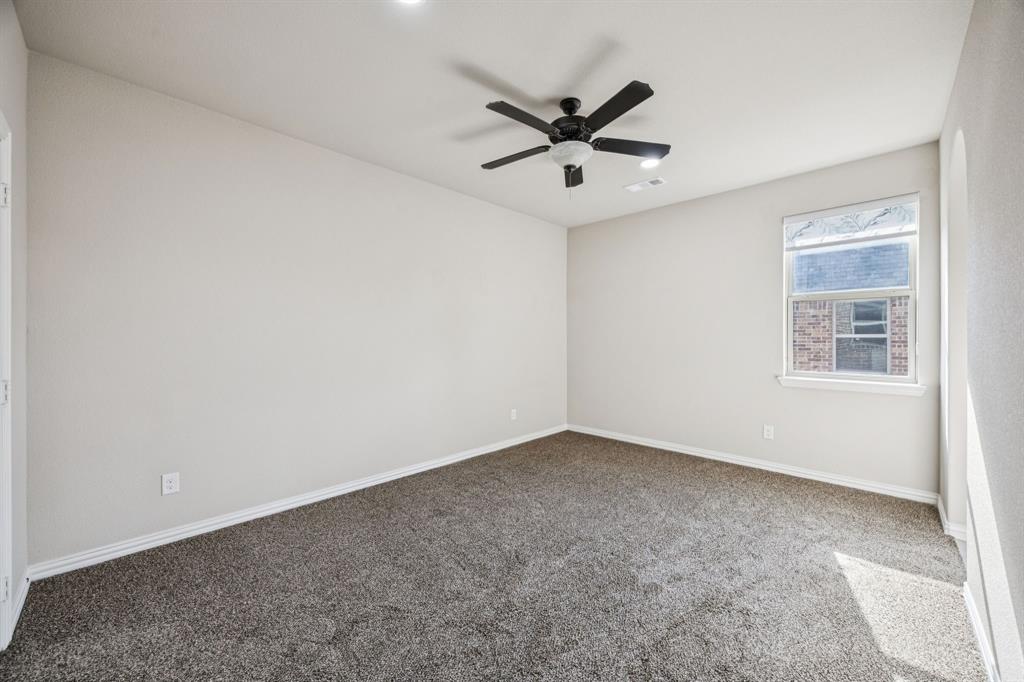 7205 Joshua Tree Trail McKinney, TX 75070 - Photo 29 of 32 an empty room with a window and a fan