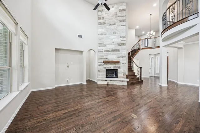 a view of empty room with fireplace and wooden floor