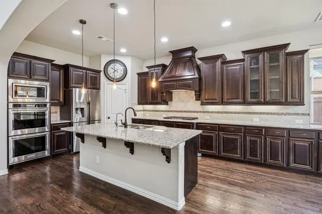 a kitchen with stainless steel appliances granite countertop a stove and cabinets