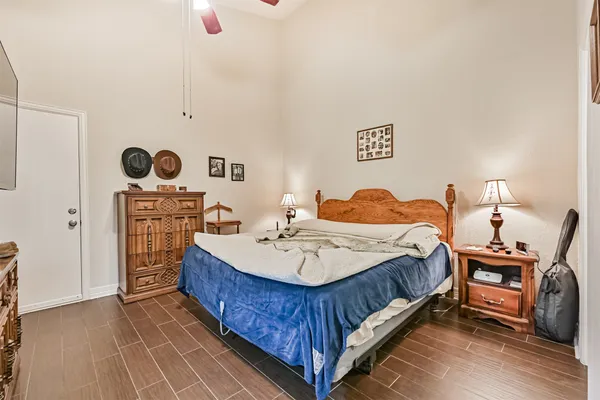 a bedroom with a bed a dresser and potted plants