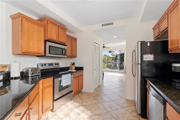 a kitchen with stainless steel appliances granite countertop a stove a sink and a microwave