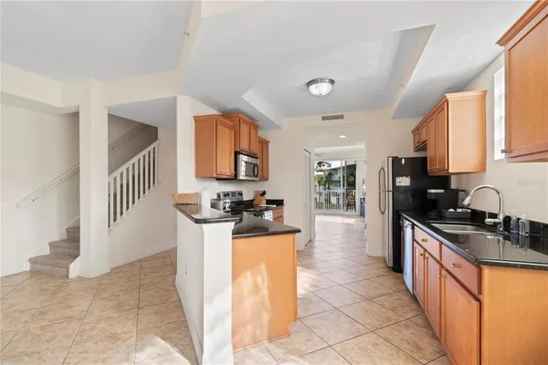 a kitchen with granite countertop a sink stove and cabinets