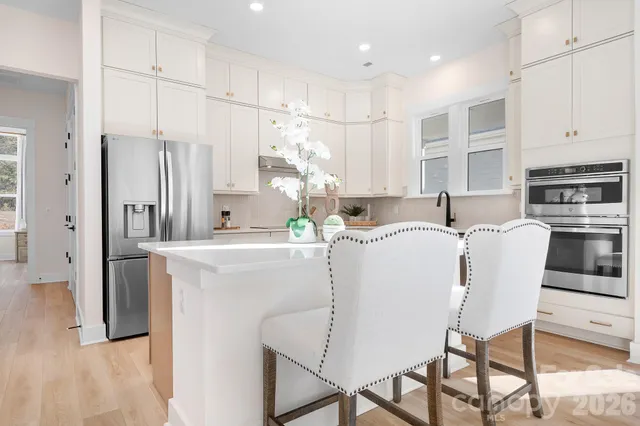 a view of a hallway with wooden floor and windows