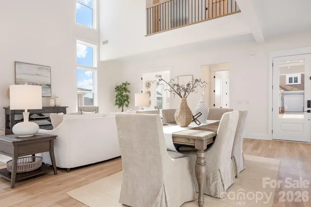 a kitchen with stainless steel appliances kitchen island granite countertop a refrigerator a stove a sink and white cabinets with wooden floor