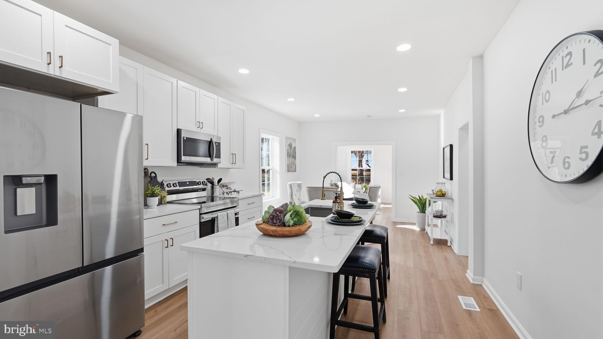 12219 River Road Remington, VA 22734 - Photo 5 of 31 a kitchen with stainless steel appliances a dining table chairs stove refrigerator and microwave