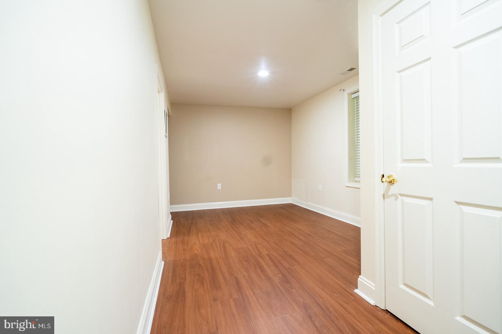 5705 Solomons Island Road St. Leonard, MD 20685 - Photo 40 of 46 a view of a hallway with wooden floor