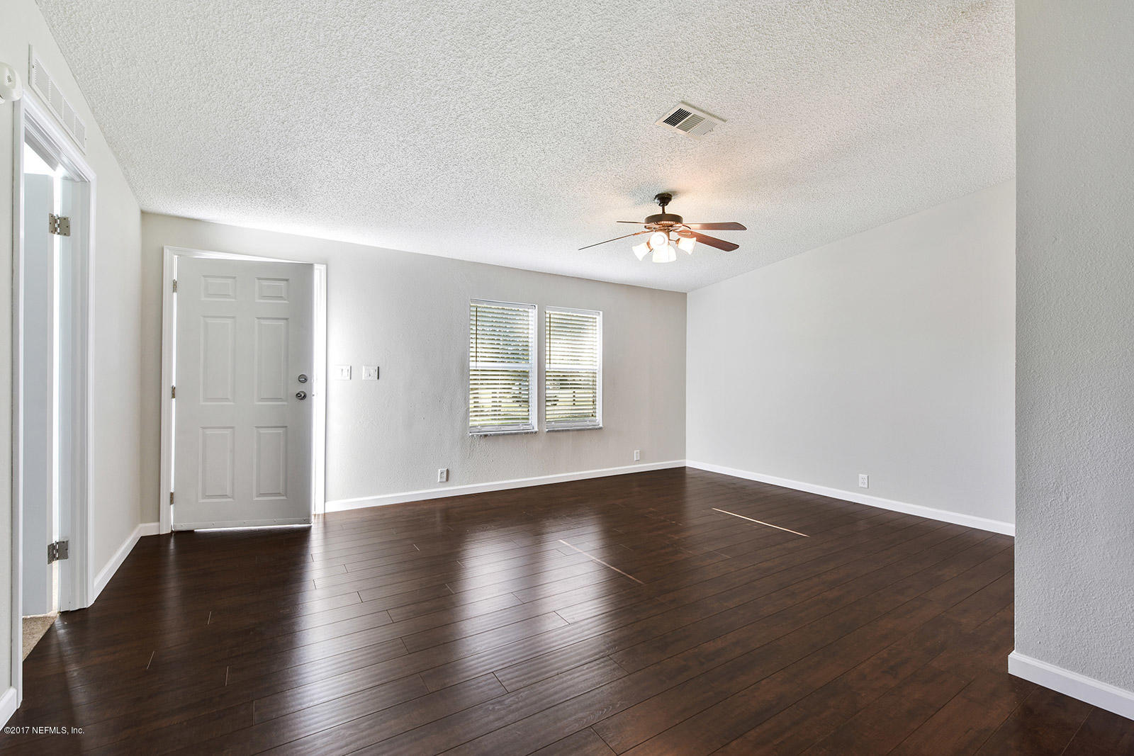 54663 Dornbush Road Callahan, FL 32011 - Photo 5 of 24 an empty room with wooden floor and windows