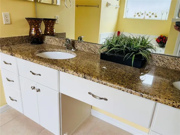 a bathroom with a granite countertop sink and a mirror