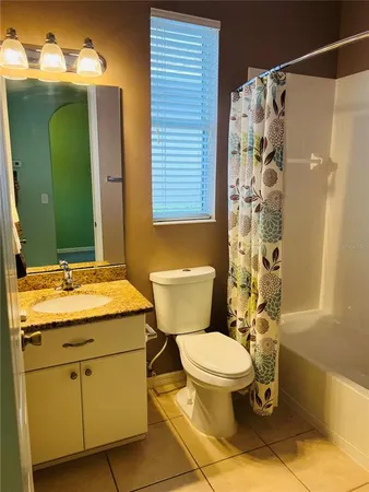a bathroom with a granite countertop toilet sink and mirror