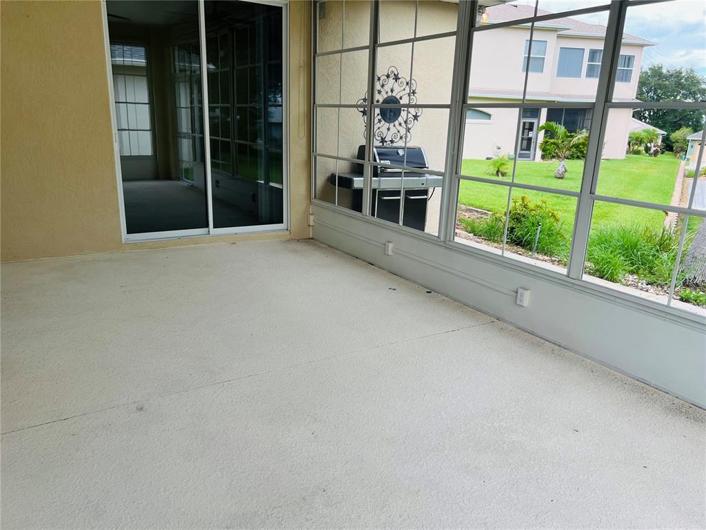 5446 Sea Leopard Street Tavares, FL 32778 - Photo 19 of 39 a view of a porch with a floor to ceiling window and yard