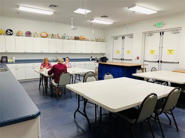 a kitchen with a dining table chairs and white appliances