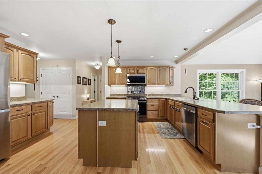 345 Bragg Road Warren, MA 01585 - Photo 15 of 41 a kitchen with stainless steel appliances granite countertop a refrigerator a sink dishwasher a stove and white countertops with wooden floor