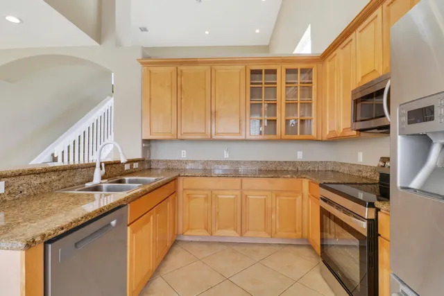 a kitchen with stainless steel appliances granite countertop a sink stove and cabinets