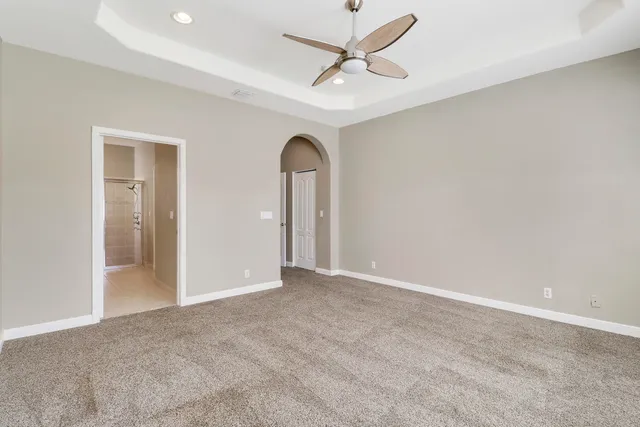 an empty room with a ceiling fan and a window