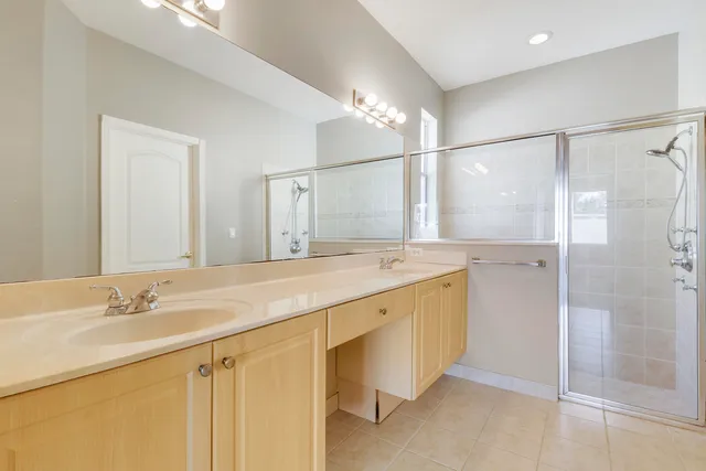 a bathroom with a double vanity sink mirror and shower