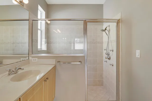 a bathroom with a shower sink and mirror