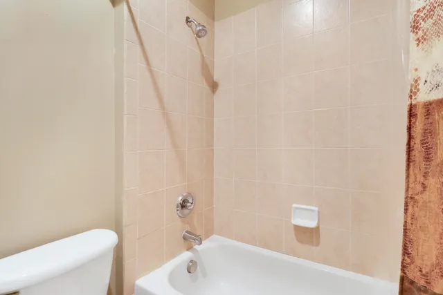 a bathroom with a white bath tub and a toilet