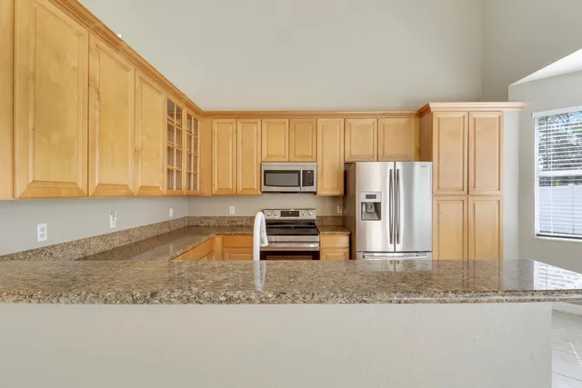 a kitchen with stainless steel appliances granite countertop a refrigerator a stove a sink and dishwasher