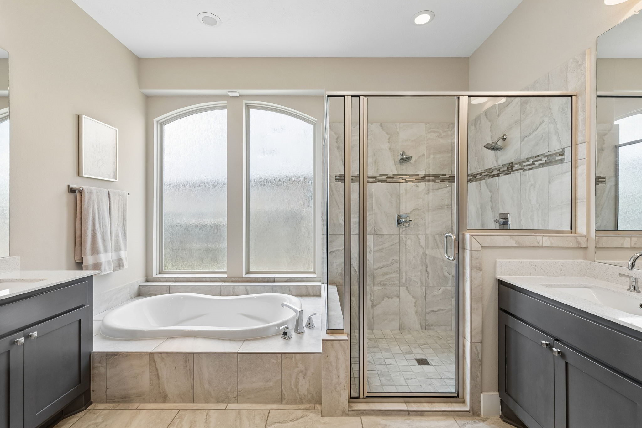 6514 Woodleaf Lake Loop Katy, TX 77493 - Photo 14 of 32 This luxurious bathroom features a separate glass-enclosed shower, a deep soaking tub, and double vanities with upgraded faucets. High-end tile flooring and large privacy-glass windows create a bright, resort-style escape.