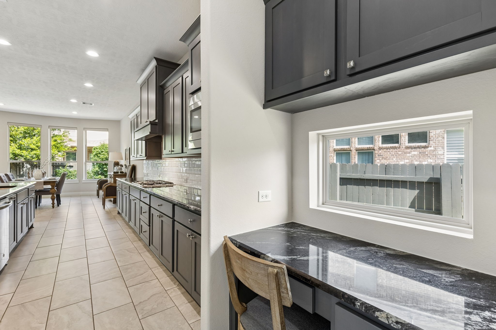 6514 Woodleaf Lake Loop Katy, TX 77493 - Photo 21 of 32 Perfectly situated between the kitchen and the versatile extra room, this built-in desk area serves as a seamless transition within the home. Featuring premium granite countertops and custom dark-toned cabinetry.
