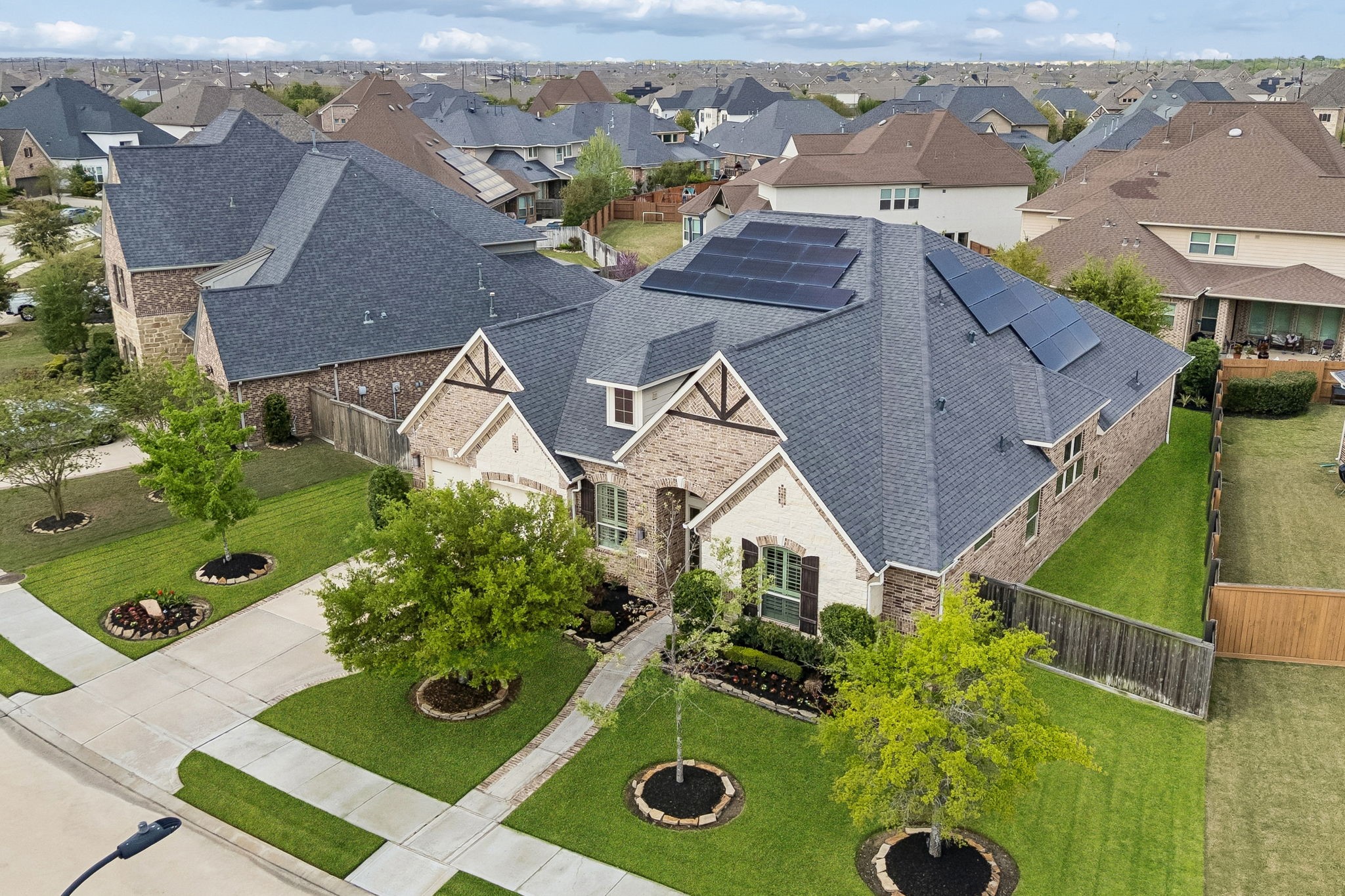6514 Woodleaf Lake Loop Katy, TX 77493 - Photo 30 of 32 Aerial view showcasing the home’s well-maintained landscaping, spacious lot, and rooftop solar panel system for added efficiency. Solar panels will be fully paid off by the seller at closing, offering immediate energy savings to the next owner.