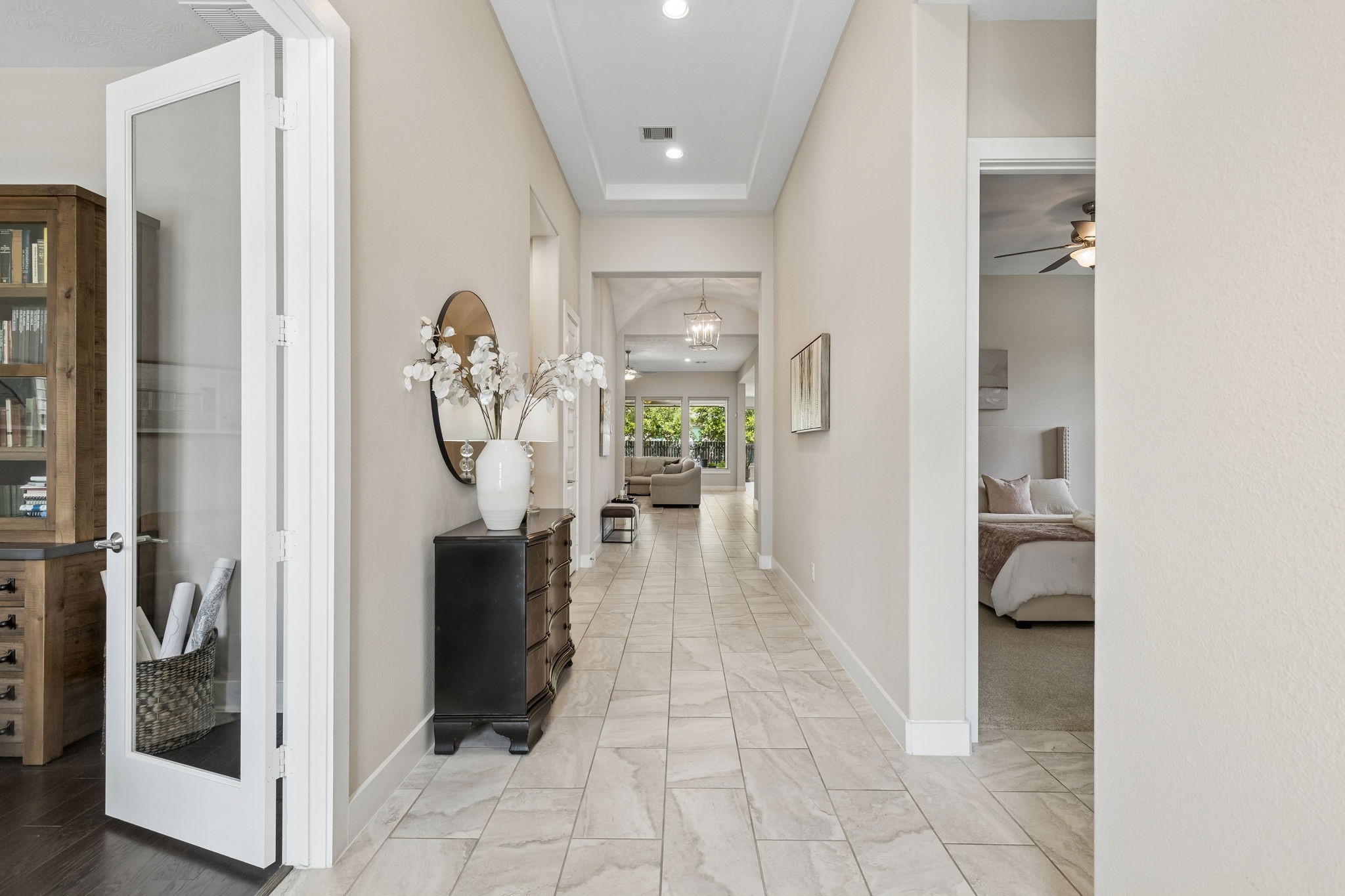 6514 Woodleaf Lake Loop Katy, TX 77493 - Photo 5 of 32 The grand entry gallery features high tray ceilings, recessed lighting, and premium tile flooring that carries through the main living areas. Elegant French doors lead to the executive study, while wide 8-foot doorways emphasize the home's impressive scale.
