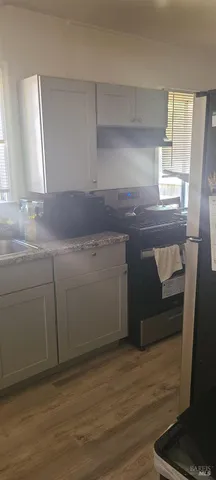 a room with a sink cabinets and a wooden floor